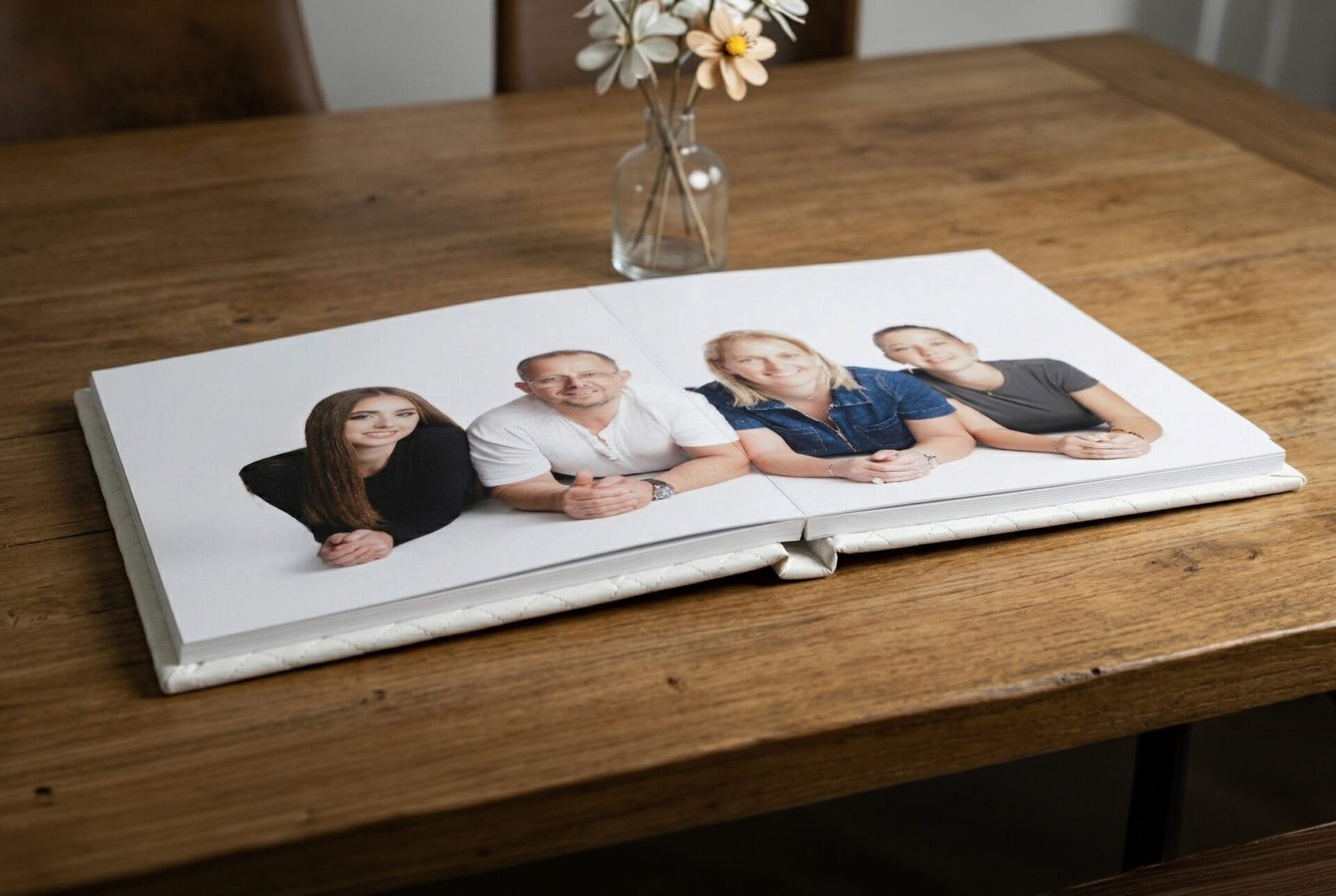 Album ouvert à plat, avec une couverture blanche en simili-cuir, issu d'une séance famille posé su