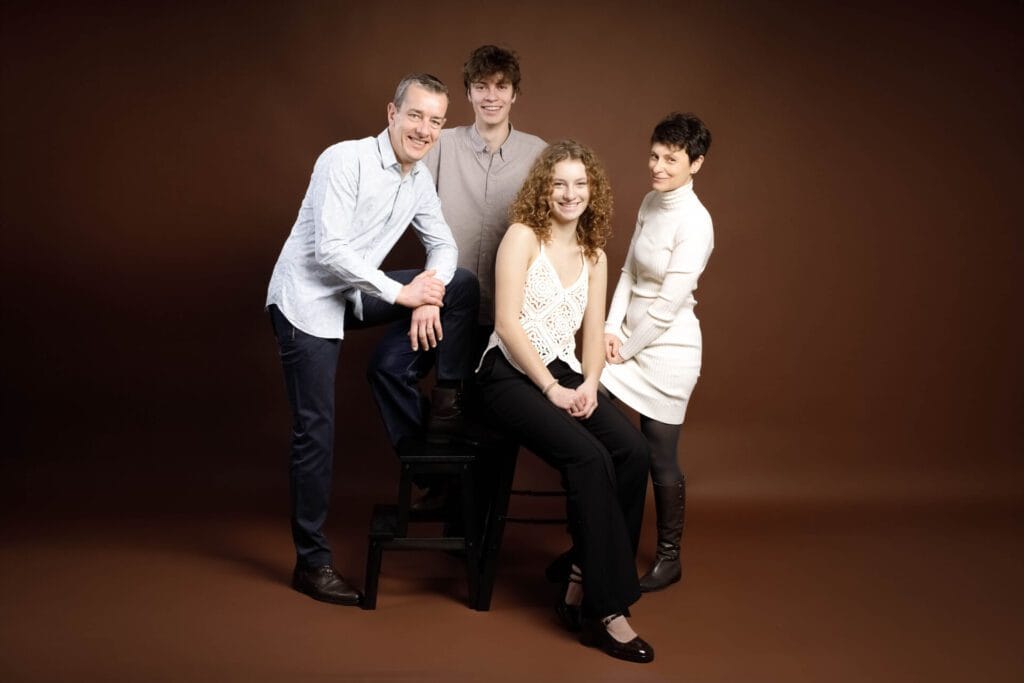 Famille posant sur fond marron, style Fine Art, Studio Salvucci, Photographe Metz