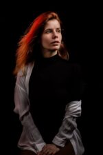 Portrait dramatique femme rousse, regard pensif, fond noir, photographiée par le Studio Salvucci à Metz.