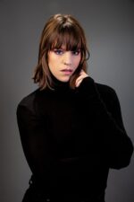 Femme aux yeux bleus intenses, cheveux bruns, col roulé noir photographiée par le Studio Salvucci à Metz.