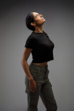 Femme en top court noir et pantalon cargo vert regardant vers le haut photographiée par le Studio Salvucci à Metz.
