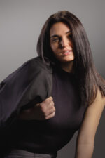 Femme élégante posant avec veste noire sur fond gris photographiée par le Studio Salvucci à Metz.