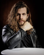 Homme aux cheveux bouclés, barbe, veste en cuir, regard intense photographié par le Studio Salvucci à Metz.
